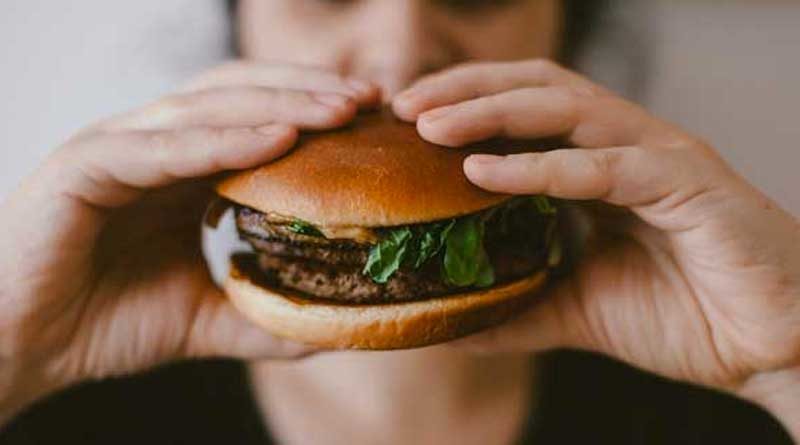 Mujer comiendo una hamburguesa