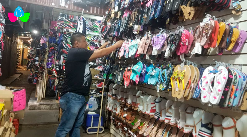 Comerciante del Mercado Roberto Huembes de Managua en su puesto de venta, acomodando su mercadería