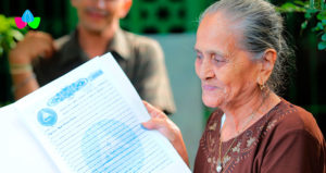 Señora sostiene en sus manos el título de su propiedad, recién entregado por la Procuraduría General de la República de Nicaragua.