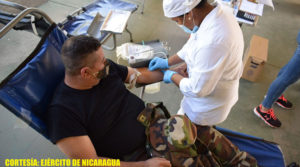 Soldado del Ejército de Nicaragua acostado en una camilla donando sangre.