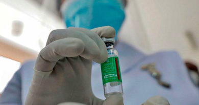 Ampolla de la vacuna contra el covid-19 Covishield, fabricada en la India; sostenida por médico sobre sus dedos.