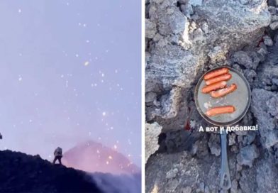 Turistas a la orilla de cráter y asando salchichas en la lava del volcán en Rusia