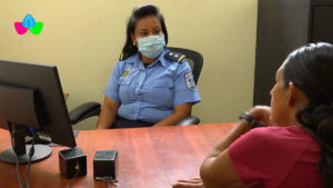 Oficial de la Policía Nacional atendiendo en la Comisaría de la Mujer de Quilalí a una pobladora mujer.