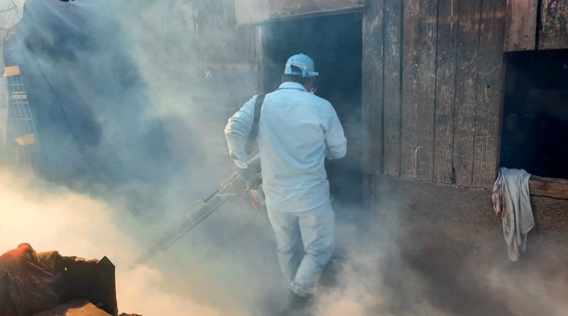 Brigadista del Ministerio de Salud fumigando una vivienda en el barrio La Primavera