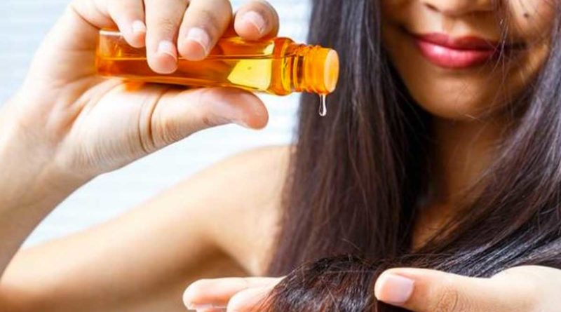 Mujer aplicando aceite en su cabello