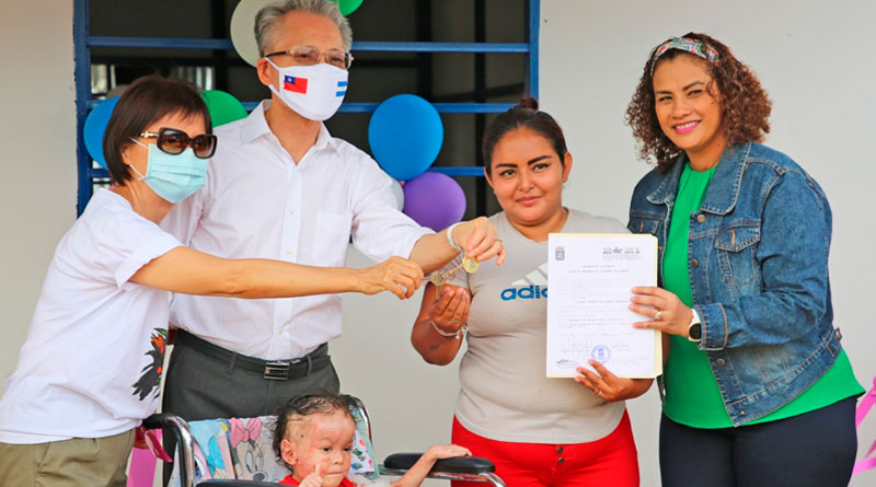 Representantes de la Alcaldía de Managua y embajada de Taiwán en Nicaragua, entregando las llaves de la nueva Vivienda Digna a la protagonista.