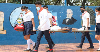Jóvenes del Colegio Salvador Mendieta cargan con una estudiante durante el ejercicio desarrollado