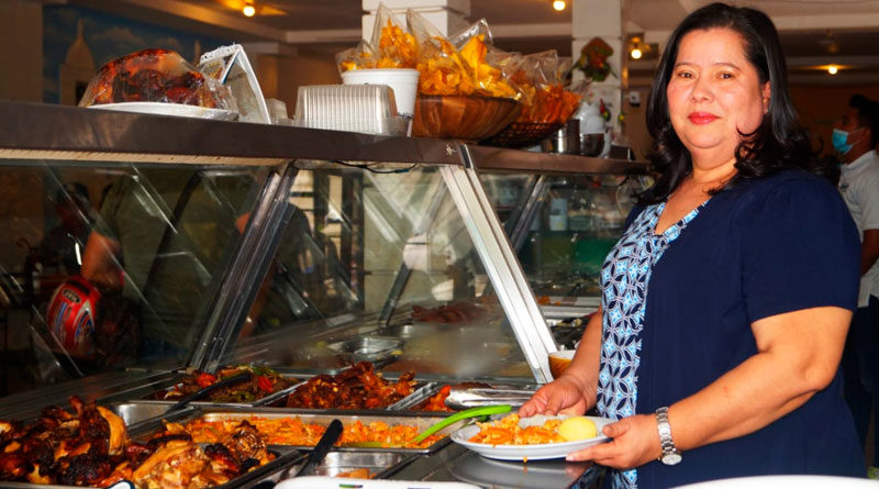 Marlene Reyes, propietaria del restaurante Llamarada del Bosque junto a un exhibidor de comida en su restaurante ubicado en Ocotal, Nueva Segovia