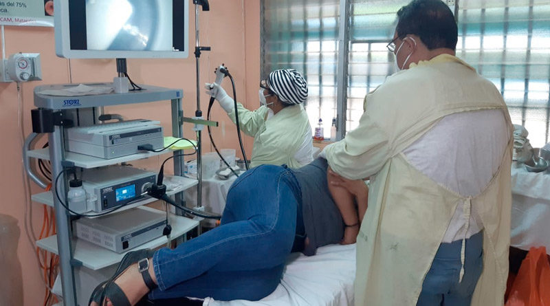 Médico realiza endoscopía a paciente acostada en una camilla