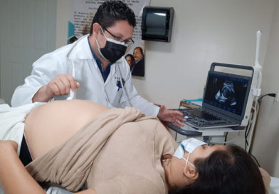 Médico especialista del MINSA realiza ultrasonido a una mujer embarazada acostada en una camilla
