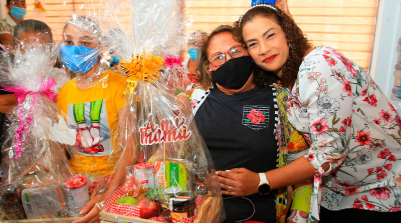 Alcaldesa de Managua, Reyna Rueda, abrazando y entregando regalo a una madre que asiste al Centro de Medicina Natural de Managua.