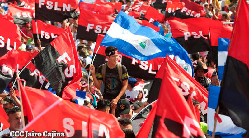 Banderas de Nicaragua y del Frente sandinista ondeadas por nicaragüenses en la Plaza de la Fe en Managua.