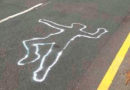Figura de cuerpo sobre el pavimento con una línea que dice escena del crimen