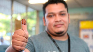 joven Nicaraguense mostrando su dedo pulgar que ejerció su voto.