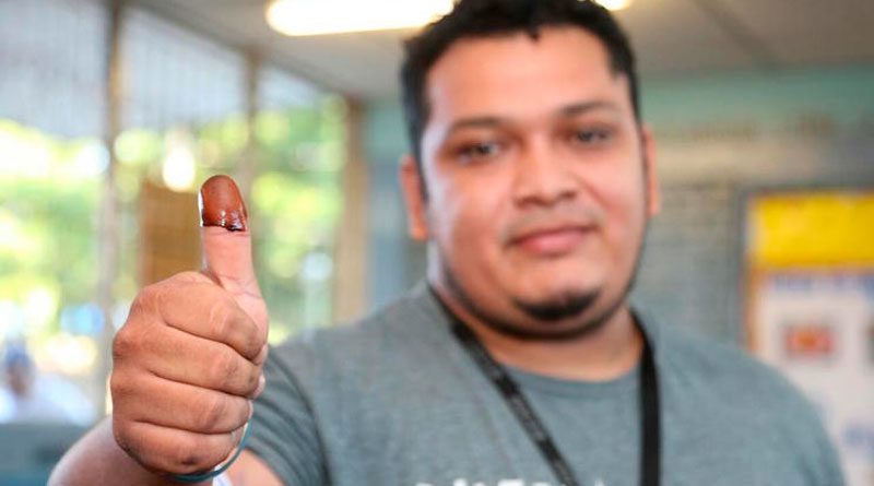 joven Nicaraguense mostrando su dedo pulgar que ejerció su voto.