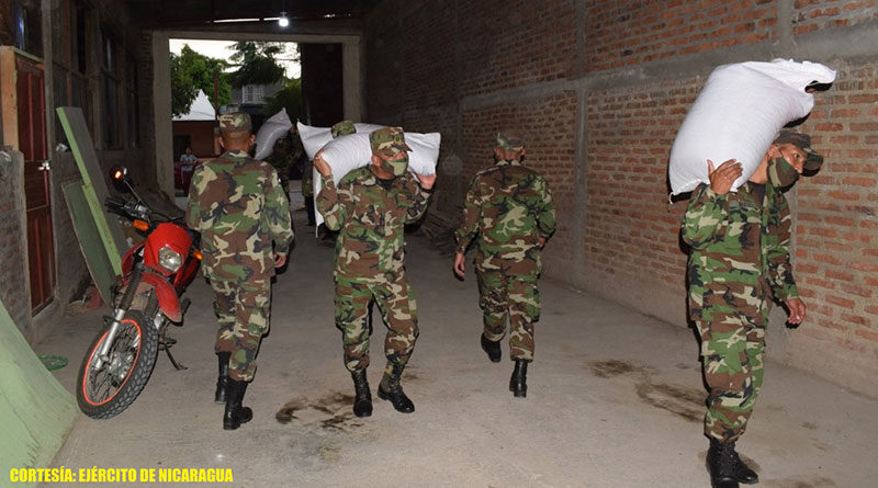 Efectivos militares del 1 Comando Militar Regional descargando los 330 quintales de semilla de frijol, en la bodega ubicada en el barrio Boanerges López, de la ciudad de Estelí.