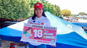 Trabajadora de Lotería Nacional de Nicaragua sostiene cartel del sorteo en homenaje al día de las madres nicaragüenses