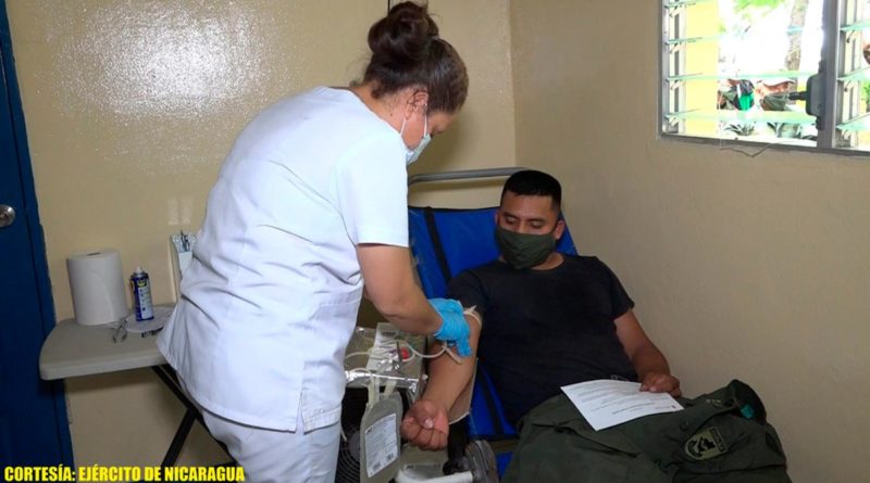 Efectivo militar durante proceso de donación de sangre junto a una enfermera