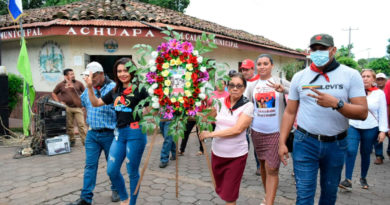 Familias de Achuapa llevando ofrendas florales al monumento dedicado a los Héroes y Mártires