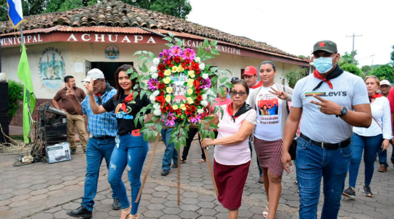 Familias de Achuapa llevando ofrendas florales al monumento dedicado a los Héroes y Mártires