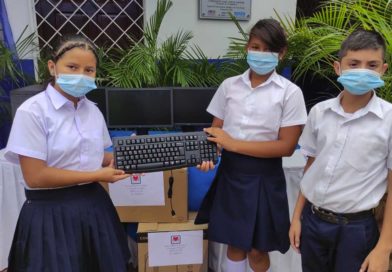 Niños estudiantes sosteniendo un teclado de computadora