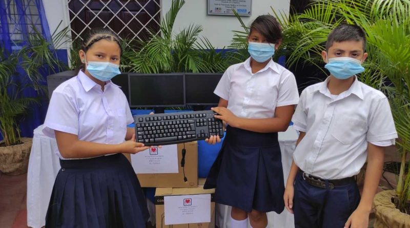 Niños estudiantes sosteniendo un teclado de computadora