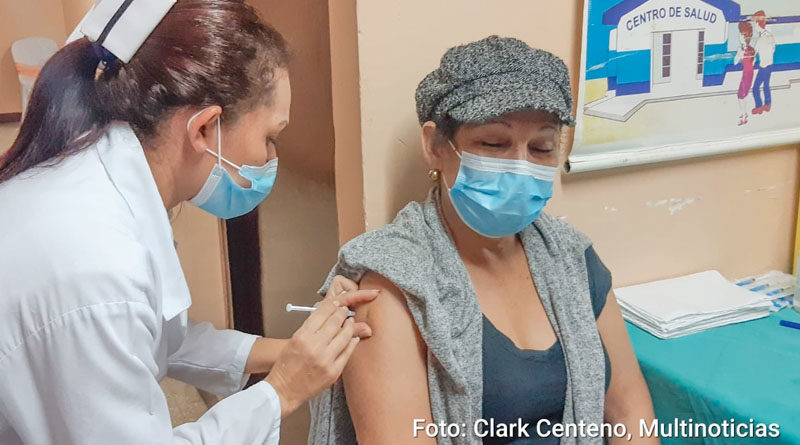 Médica del MINSA aplica vacuna a una señora en el brazo derecho