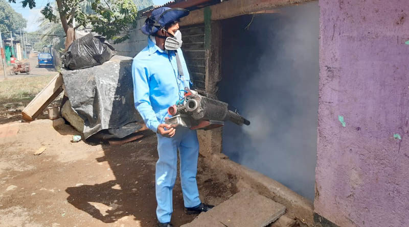 Brigadista del Ministerio de Salud fumiga una vivienda en el barrio El Recreo