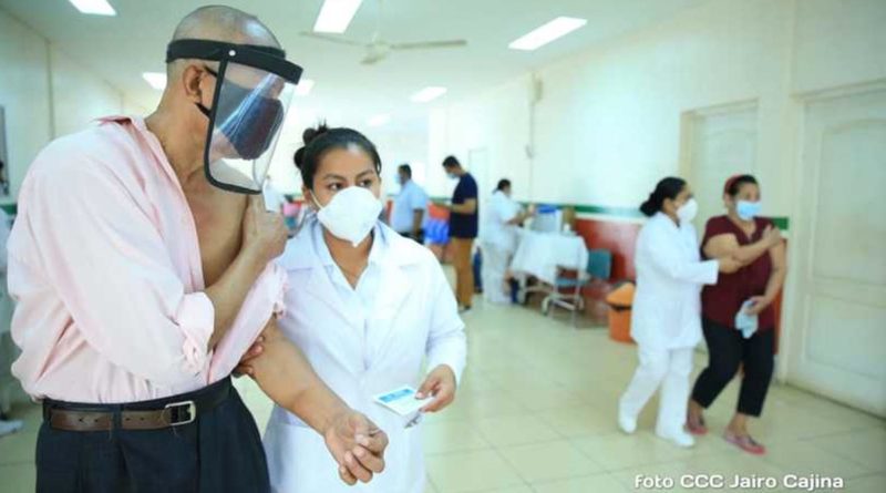 Paciente junto a enfermera después de vacunarse contra la covid-19