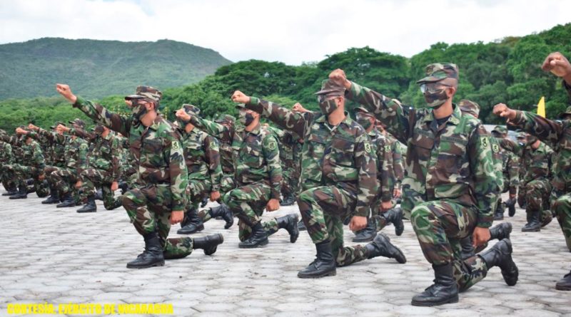 Soldados del ejercito de Nicaragua con rodilla en tierra y el bazo derecho en alto
