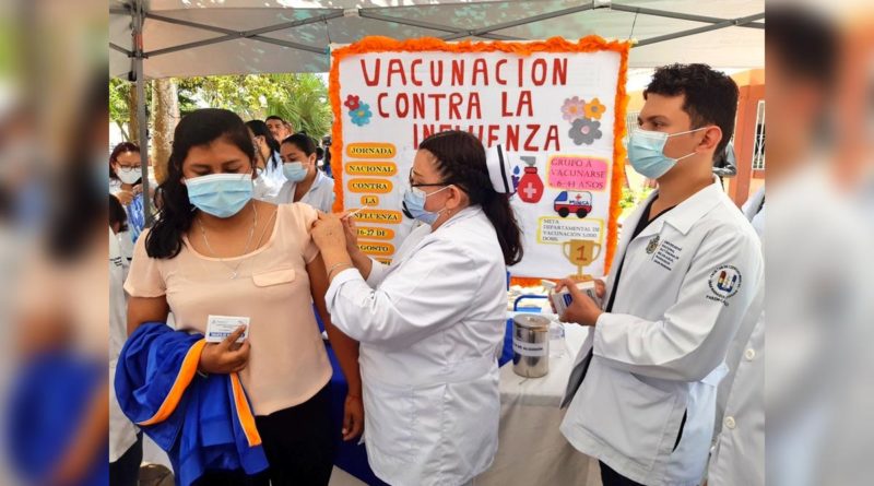 Doctora aplicando vacuna contra la Influenza a una paciente