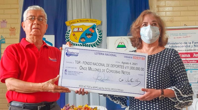 Gerente General de la Lotería Nacional, Ernesto Vallecillo haciendo entrega de cheque de utilidades al Ministerio de la Familia y al IND.