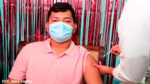 Joven nicaragüense siendo vacunado por enfermera del MINSA contra la COVID-19