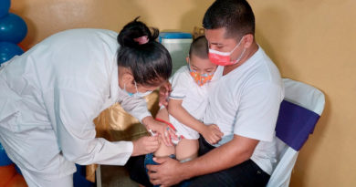 Personal médico del Ministerio de Salud aplica vacuna a un menor de edad cargado en brazos por su padre