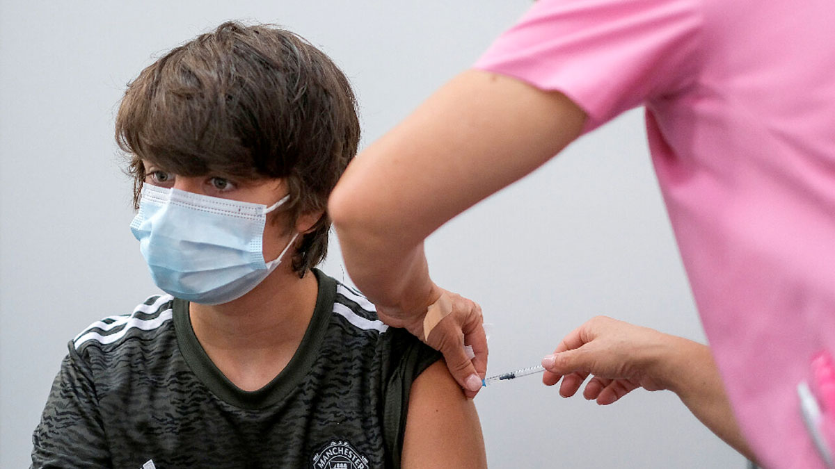 Personal médico aplicando vacuna a un menor de edad