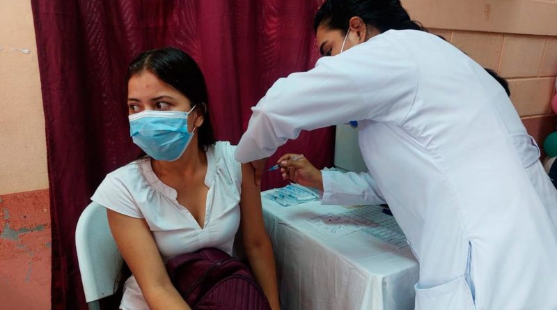 Enfermera del Ministerio de Salud de Nicaragua vacunando contra la COVID-19 a una ciudadana mayor de 18 años