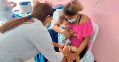 Niño en brazos de su madre siendo vacunado contra la COVID-19 por una enfermera del Ministerio de Salud de Nicaragua.