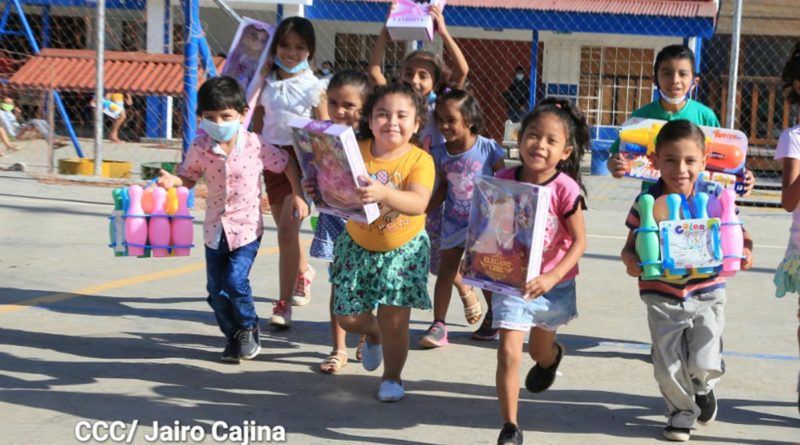 Niños corren alegremente tras recibir sus juguetes