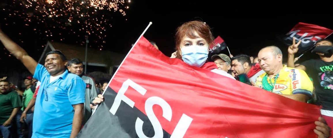 Una joven sostiene la bandera rojinegra del FSLN durante la celebración en la Plaza de las Victorias