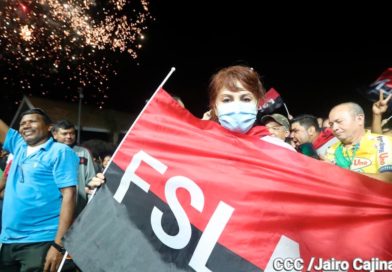 Una joven sostiene la bandera rojinegra del FSLN durante la celebración en la Plaza de las Victorias