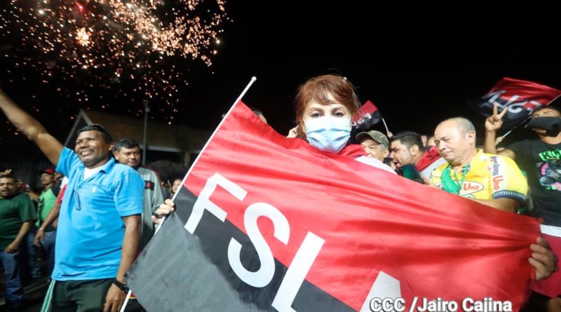 Una joven sostiene la bandera rojinegra del FSLN durante la celebración en la Plaza de las Victorias