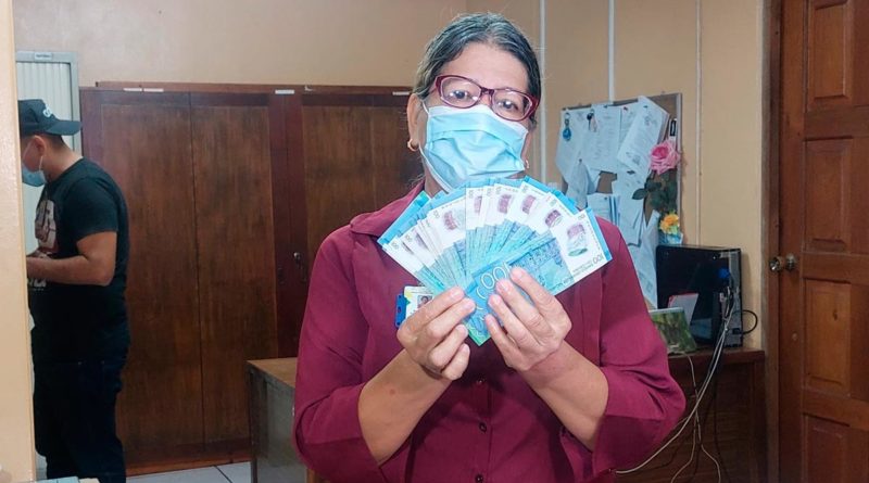 Trabajadora del Estado de Nicaragua con su salario adelantado en sus manos