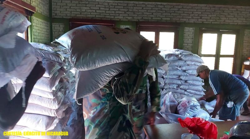 Efectivos militares del Destacamento Militar Norte durante el descargue de 1,000 paquetes de semillas de frijoles rojos en la bodega del INTA en Waspam.