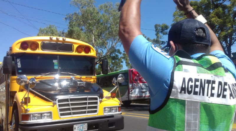 Oficial de transito ejerciendo el proceso de inspección a un bus de transporte escolar