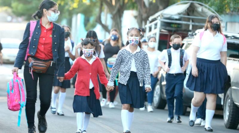 Madre de familia junto a estudiantes en el primer día de clases 2022