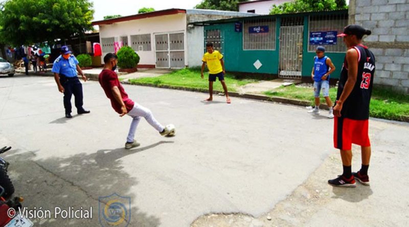 Jóvenes jugando fútbol en una calle