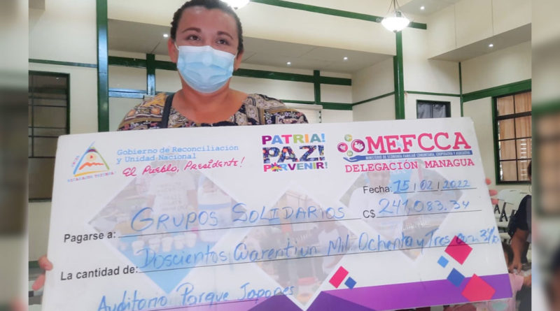 Protagonista de MEFCCA recibiendo cheque como parte del programa emprendimiento para el campo.