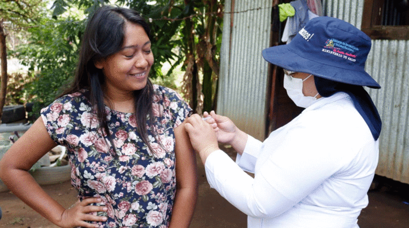 Enfermera del Ministerio de Salud de Nicaragua (MINSA), vacunando contra la COVID-19 a una habitante del barrio Frawley de Managua.