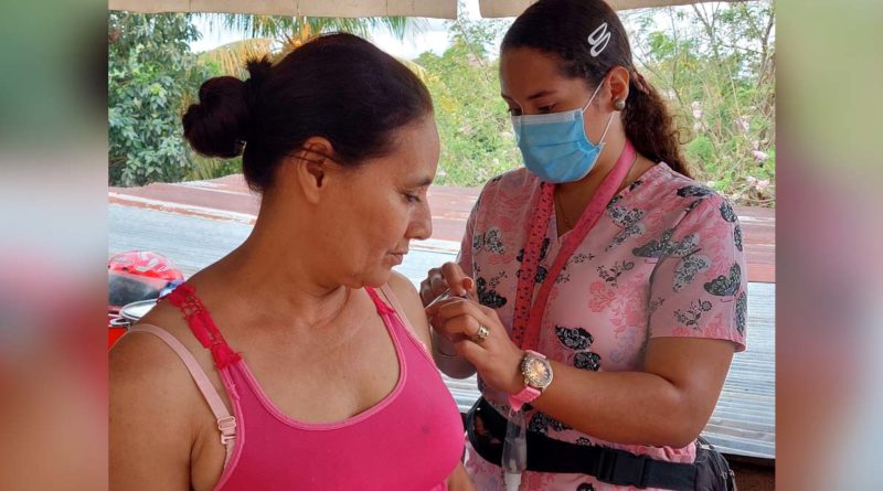 Brigadista del Ministerio de Salud aplica vacuna contra el COVID-19 a una pobladora en el barrio Camilo Ortega