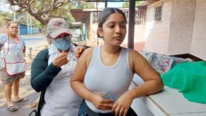 Brigadista del Ministerio de Salud aplica vacuna contra el COVID-19 a una joven en Villa Cuba